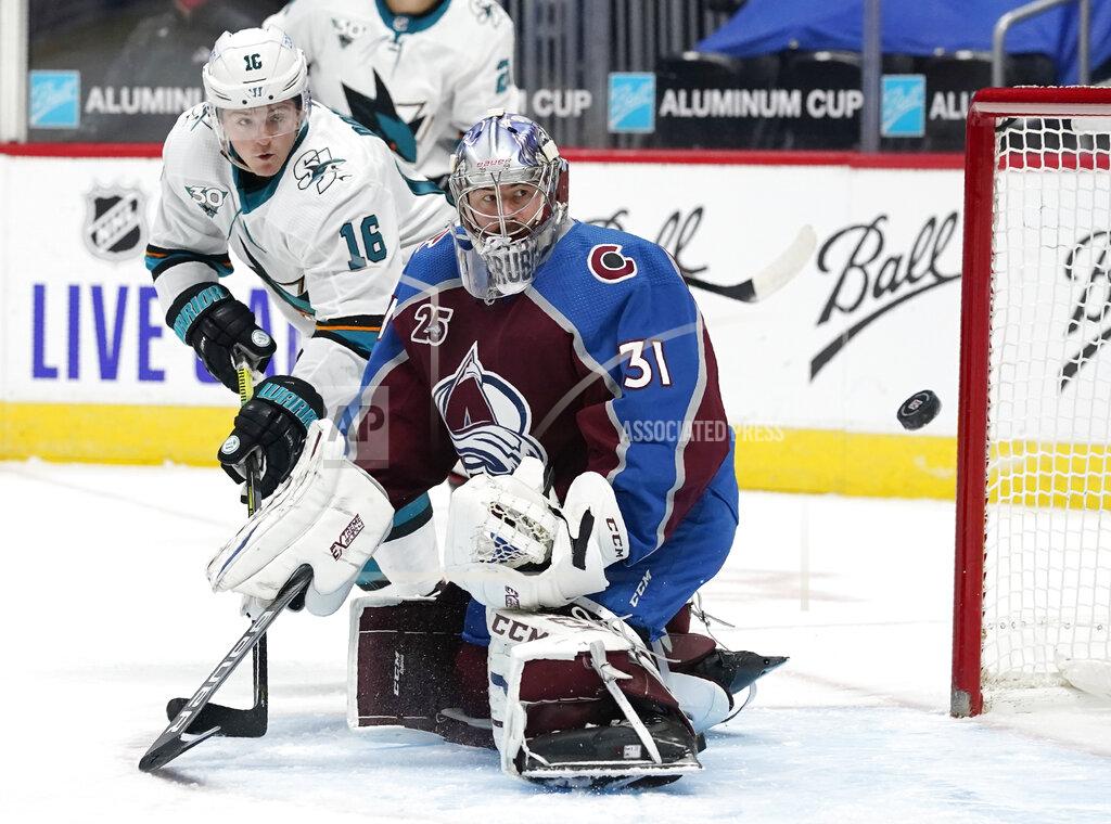 David Zalubowski San Jose Sharks center Ryan Donato, back, redirects a shot past Colorado Avalanche goaltender Philipp Grubauer and wide of the goal during the third period of an NHL hockey game Tuesday, Jan. 26, 2021, in Denver. (AP Photo/David Zalubowski)