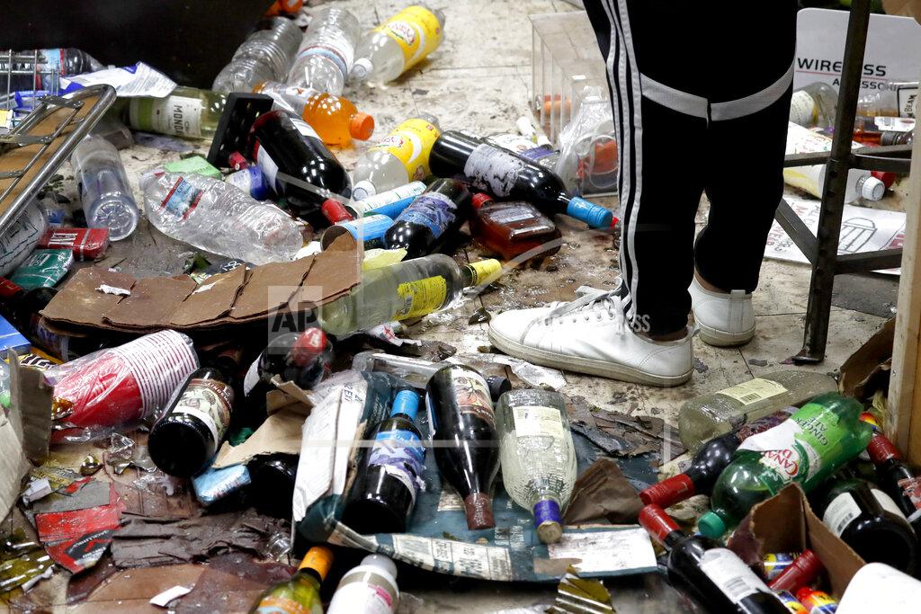 Charles Rex Arbogast FILE In this Monday, Aug. 10, 2020, file photo, Kajal Dalal walks through the her family's food and liquor store after it was vandalized in downtown Chicago. A Chicago police task force that was formed after crowds swarmed into downtown and smashed their way into hundreds of stores in August is still investigating and making arrests four months later. (AP Photo/Charles Rex Arbogast, File)
