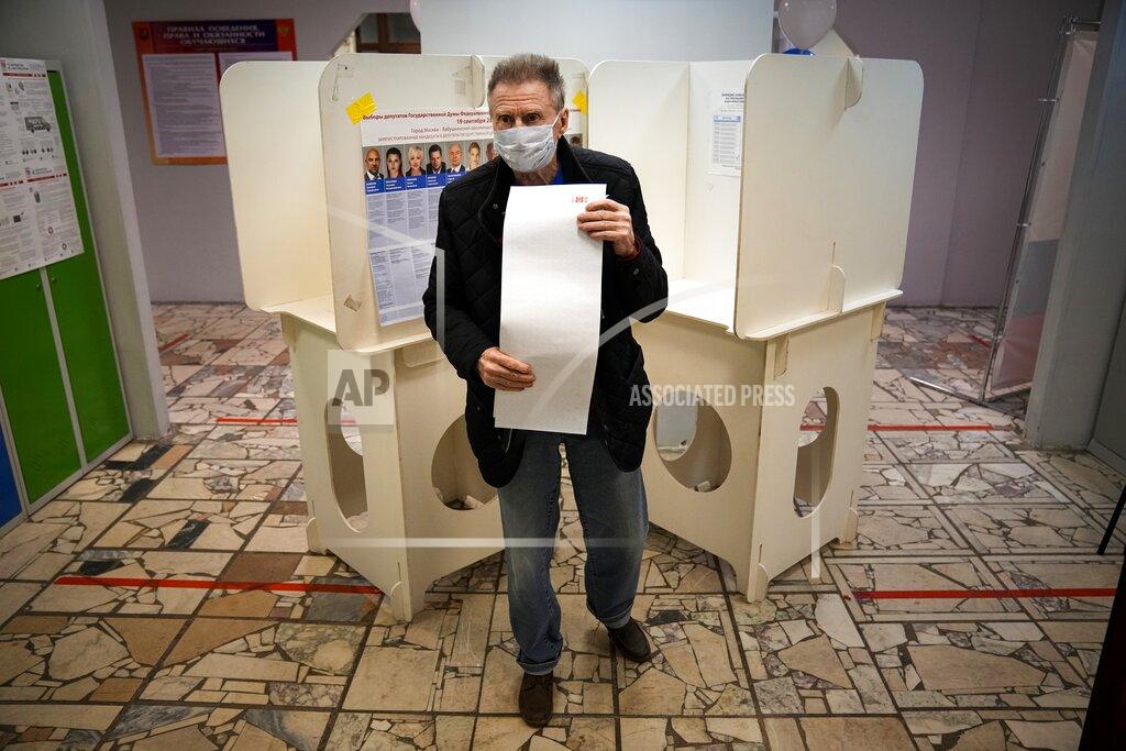 Alexander Zemlianichenko A man walks to casts his ballot at a polling station during Parliamentary elections in Moscow, Russia, Friday, Sept. 17, 2021. Russia has begun three days of voting for a new parliament that is unlikely to change the country's political complexion. There's no expectation that United Russia, the party devoted to President Vladimir Putin, will lose its dominance in the State Duma. (AP Photo/Alexander Zemlianichenko)