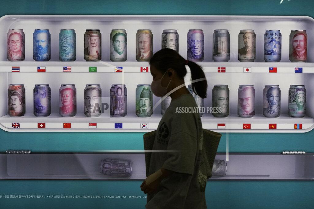 Ahn Young-Joon A woman walks by a bank's currency advertisement board in Seoul, South Korea, Friday, Sept. 23, 2022. Asian stocks fell for a third day Friday after more rate hikes by the Federal Reserve and other central banks to control persistent inflation spurred fears of a possible global recession. (AP Photo/Ahn Young-joon)