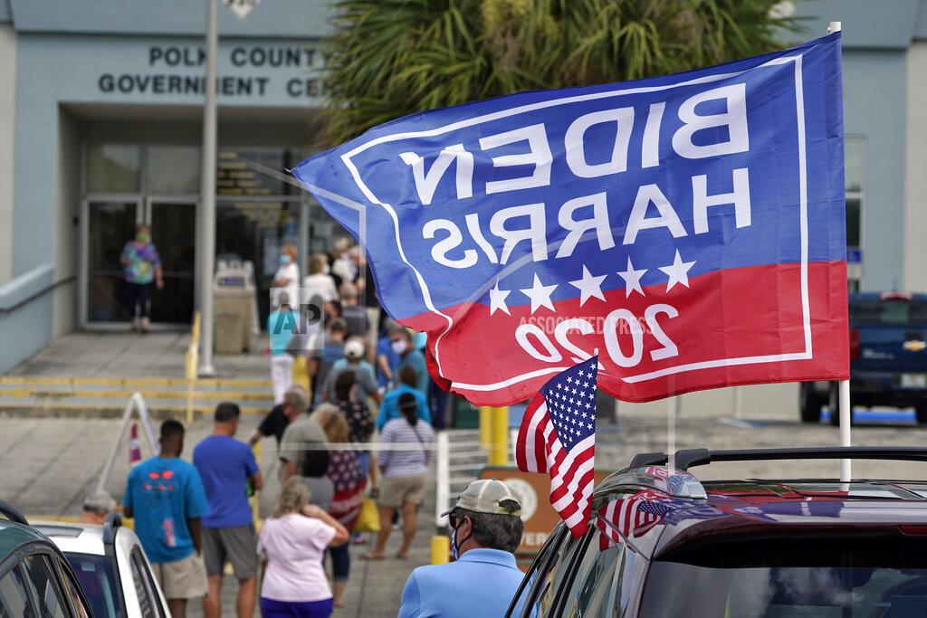 Chris O'meara A Biden/Harris 2020 flag flies in the breeze as voters wait in line Monday, Oct. 19, 2020, in Lakeland, Fla. Floridians began early voting in much of the state Monday with no serious problems reported as the Trump campaign tries to cut into an early advantage Democrats have posted in mail-in votes in the key swing state. (AP Photo/Chris O'Meara)