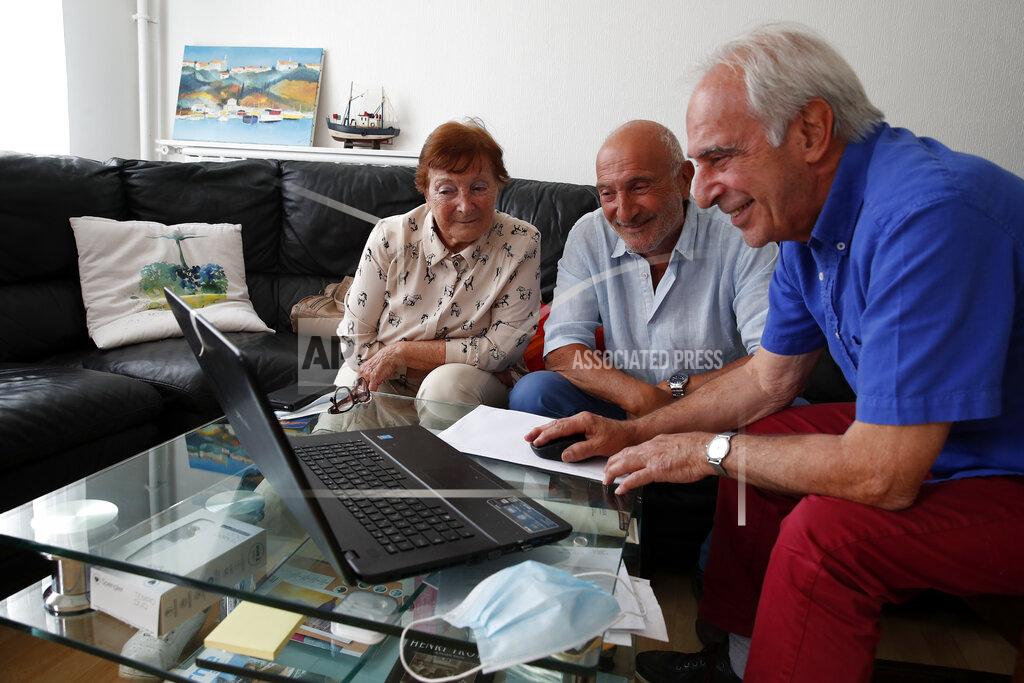 Francois Mori In this photo taken on June 5, 2020, Monette Hayoun, Dr Robert Haiun, and Gilbert Haiun, from left, look at photos of their brother Meyer Haiun on a computer during an interview in Ivry sur Seine, south of Paris. Families whose elders died behind the closed doors of homes in lockdown are filing wrongful death lawsuits, triggering police investigations. One suit focuses on the death of Meyer Haiun, a severely disabled 85-year-old in a Paris home managed by a Jewish charitable foundation headed Eric de Rothschild, scion of Europe's most famous banking dynasty. (AP Photo/Francois Mori)