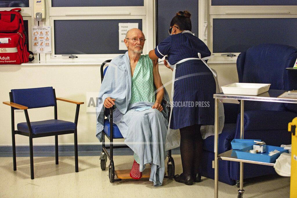 Jacob King FILE - In this Tuesday Dec. 8, 2020 file photo, "Bill" William Shakespeare, 81, receives the Pfizer-BioNTech COVID-19 vaccine, at University Hospital, Coventry, England. On Friday, Dec. 11, 2020, The Associated Press reported on stories circulating online incorrectly asserting the first two recipients of the COVID-19 vaccine in Britain are “crisis actors.” At University Hospital Coventry on Dec. 8, nurse May Parsons first administered the vaccine to Margaret Keenan, 90, then to “Bill” William Shakespeare.(Jacob King/Pool via AP)