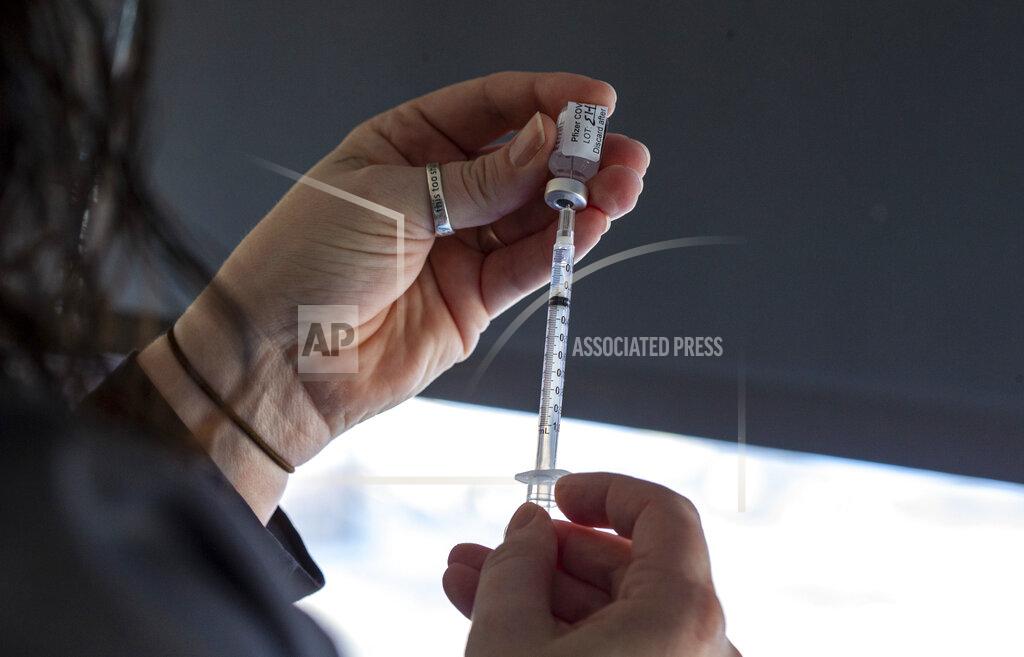 Andy Abeyta Staff nurse Rachel Lewis draws a dose of the Pfizer-BioNTech COVID-19 vaccine for a healthcare worker at the University of Iowa Hospitals and Clinics, Monday, Dec. 14, 2020, in Iowa City, Iowa. (Andy Abeyta/The Gazette via AP)