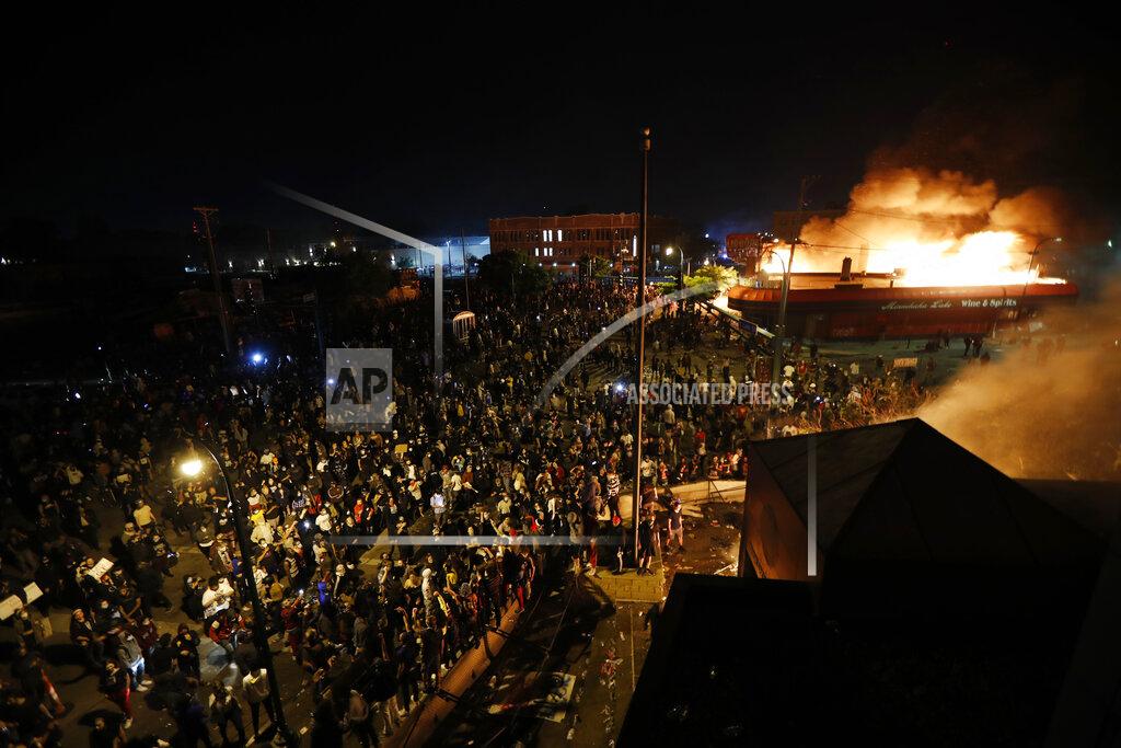 John Minchillo Protesters are seen from the roof of the Minneapolis police 3rd Precinct building Thursday, May 28, 2020, in Minneapolis. Protests over the death of George Floyd, a black man who died in police custody Monday, broke out in Minneapolis for a third straight night. (AP Photo/John Minchillo)
