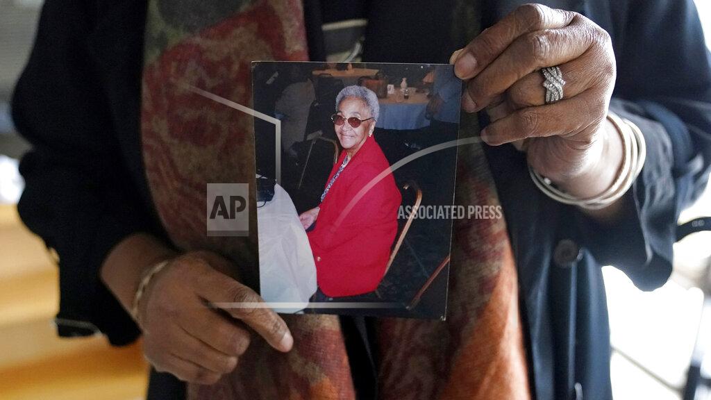 Charles Krupa Priscilla Flint-Banks holds a photograph of her 87-year-old mother, Ruby Mae Kinney, who died during April of COVID-19, Friday, Oct. 30, 2020, in the Dorchester neighborhood of Boston. Once a coronavirus hot spot, Massachusetts was seen as a model for infection control this summer as coronavirus cases and deaths dwindled. Now, experts are warning the state could be headed for a bleak winter as its cases climb once again and confirmed deaths surpass 10,000. Massachusetts hit 10,015 confirmed coronavirus deaths on Thursday, Nov. 12, 2020 nearly nine months after the state’s initial case was detected. (AP Photo/Charles Krupa)