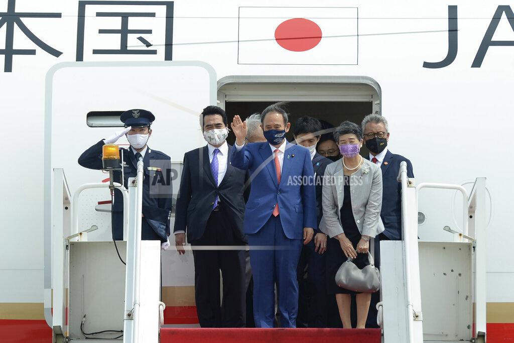 Uncredited In this photo released by Indonesian Presidential Palace, Japanese Prime Minister Yoshihide Suga, center, waves, accompanied by his wife Mariko Suga, left in foreground, upon arrival at Halim Perdanakusuma Airport in Jakarta, Indonesia, Tuesday, Oct. 20, 2020. Suga arrived in Indonesia on the second leg of his first overseas trip as premier to underscore his government’s aims of countering China in the region (Indonesian Presidential Palace via AP)