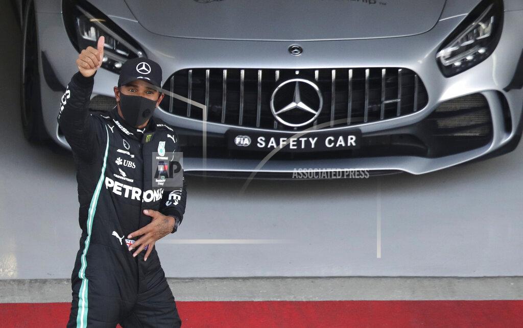 FILE - In this file photo dated Saturday, Sept. 26, 2020, Mercedes driver Lewis Hamilton of Britain gives the thumbs up after clocking the fastest time during qualifying for the Russian Formula One Grand Prix, at the Sochi Autodrom circuit, in Sochi, Russia. Victory at the Portuguese Grand Prix on upcoming Sunday Oct. 25, 2020, would move the British driver onto 92 wins, and surpass the German great Michael Schumacher's mark of 91 that for so long within F1 had been considered untouchable. (AP Photo/Pavel Golovkin, FILE)