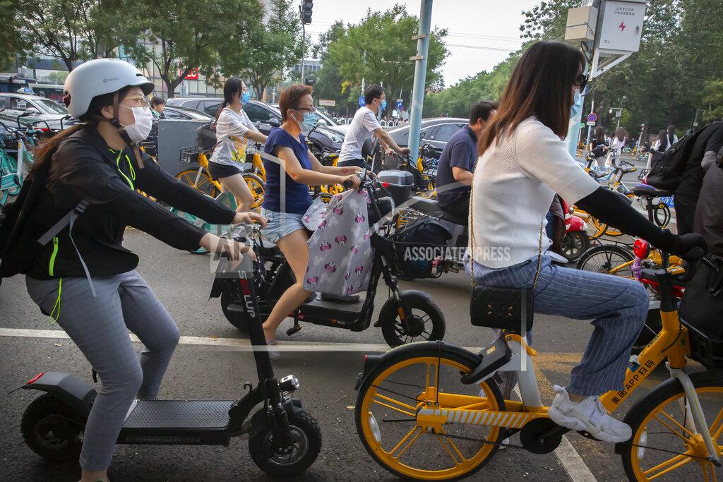Mark Schiefelbein People wearing face masks to protect against the coronavirus wait at an intersection in Beijing, Wednesday, July 29, 2020. China reported more than 100 new cases of COVID-19 on Wednesday as the country continues to battle an outbreak in Xinjiang. (AP Photo/Mark Schiefelbein)