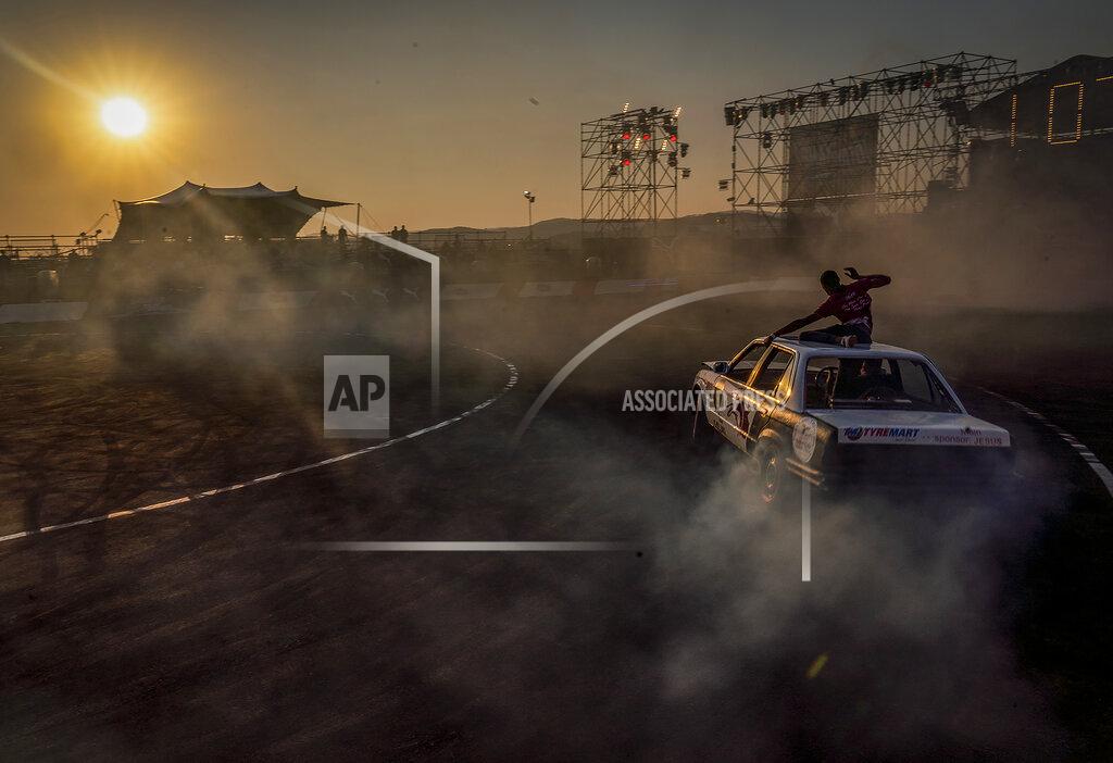 Shiraaz Mohamed Redwan Hoff sits on the roof of a BMW while driver Lorenzo Dada competes in the Redbull Shay iMoto, a spinning event where twelve of the best spinners from South Africa gather to showcase their spinning skills and stunts in Johannesburg, Friday, Sept 10, 2021. (AP Photo/Shiraaz Mohamed.
