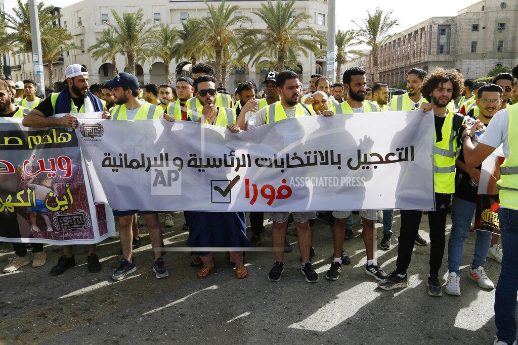 Yousef Murad Protesters demonstrate in Martyrs Square in Tripoli, Libya, Friday, July 1, 2022, calling for election and protesting against the government and parliament. The banner reads, “Acceleration of the presidential and parliamentary elections, Immediately." (AP Photo/Yousef Murad)