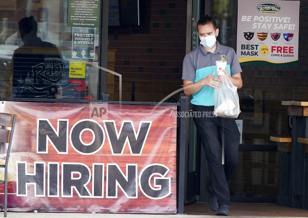 FILE - In this Sept. 2, 2020 file photo, a customer wears a face mask as they carry their order past a now hiring sign at an eatery in Richardson, Texas. The number of Americans seeking unemployment benefits fell last week to 751,000, the lowest since March, but it's still historically high and indicates the viral pandemic is still forcing many employers to cut jobs. (AP Photo/LM Otero, File)