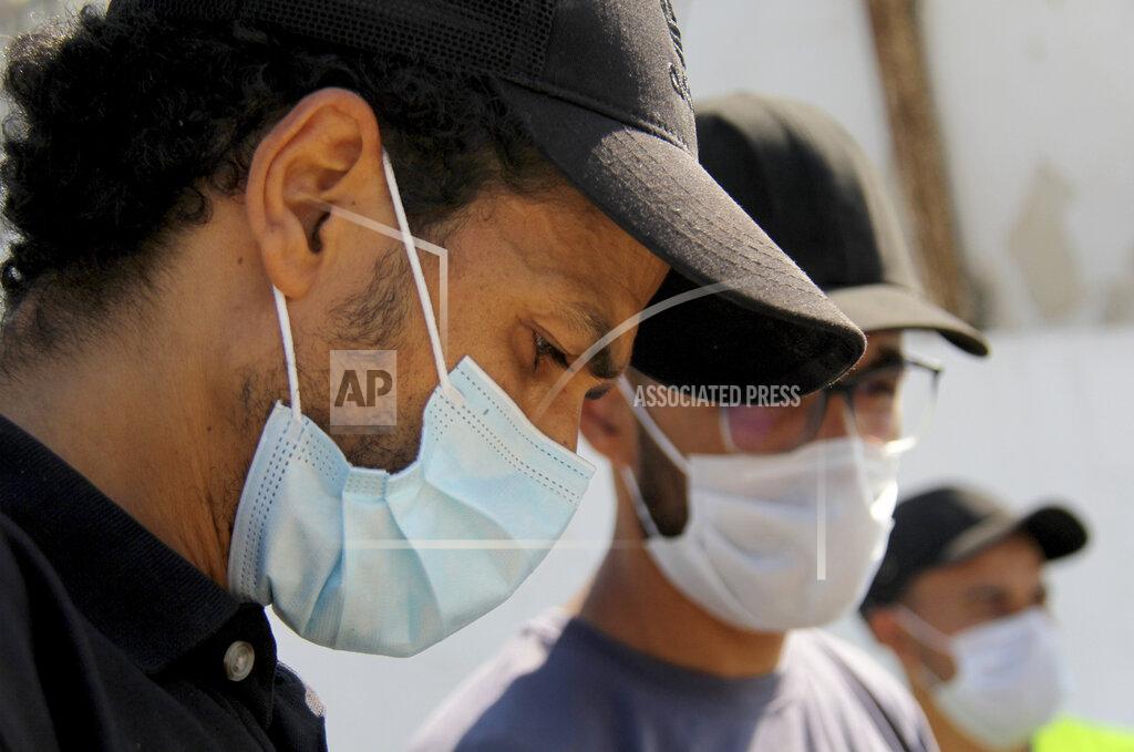 Hassene Dridi People wearing face masks to protect from COVID-19 stand outside a hospital in Tunis, Tunisia, Wednesday, July 21, 2021. Tunisia's president on Wednesday ordered the military to take over management of the national COVID-19 pandemic response, as the country fights one of Africa's worst outbreaks. (AP Photo/Hassene Dridi)