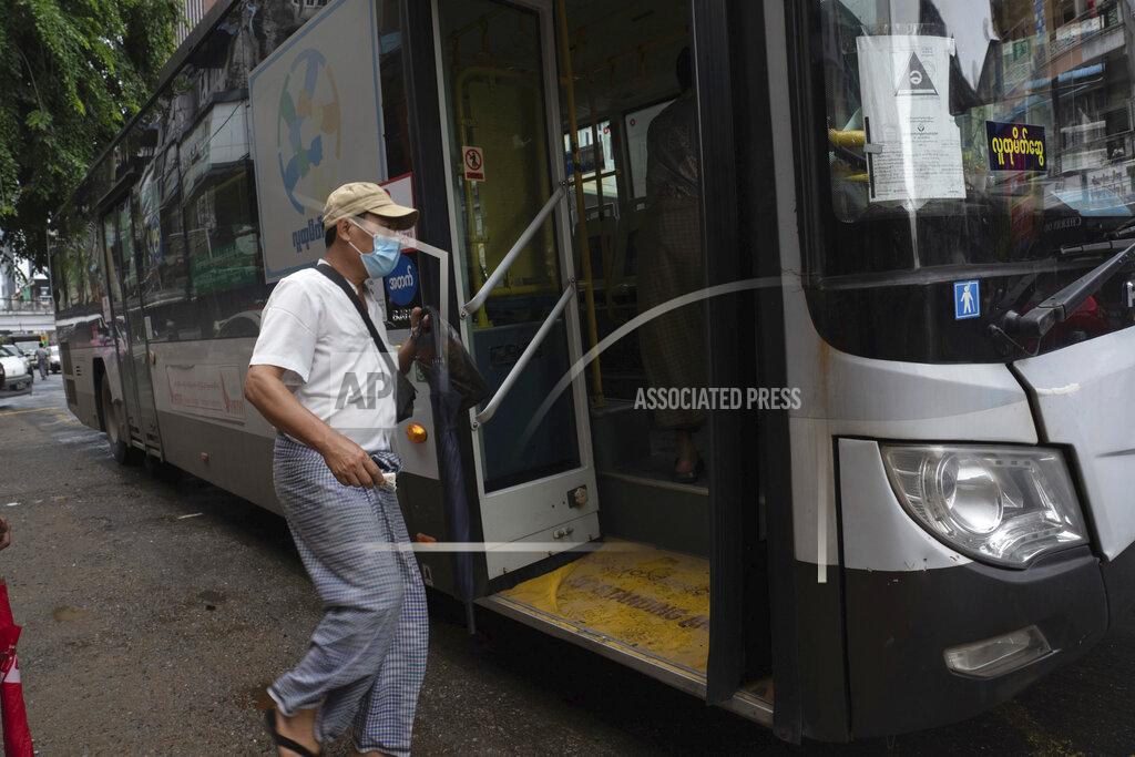 Pyae Sone Win A commuter wearing a face mask boards a bus in Yangon, Myanmar,Monday, Sept. 21, 2020. Myanmar, faced with a rapidly rising number of coronavirus cases and deaths, has imposed the tightest restrictions so far to fight the spread of the disease in Yangon, the country's biggest city and main transportation hub. (AP Photo/Pyae Sone Win)
