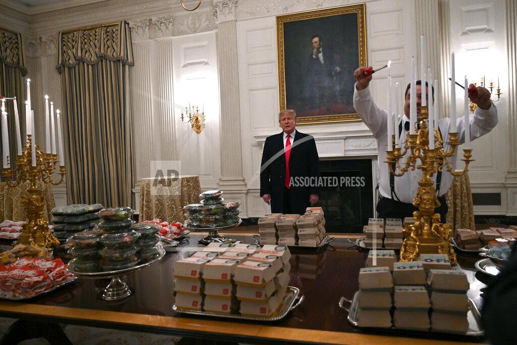 Susan Walsh President Donald Trump talks to the press about the table full of fast food in the State Dining Room of the White House in Washington, Monday, Jan. 14, 2019, for the reception for the Clemson Tigers. (AP Photo/Susan Walsh)