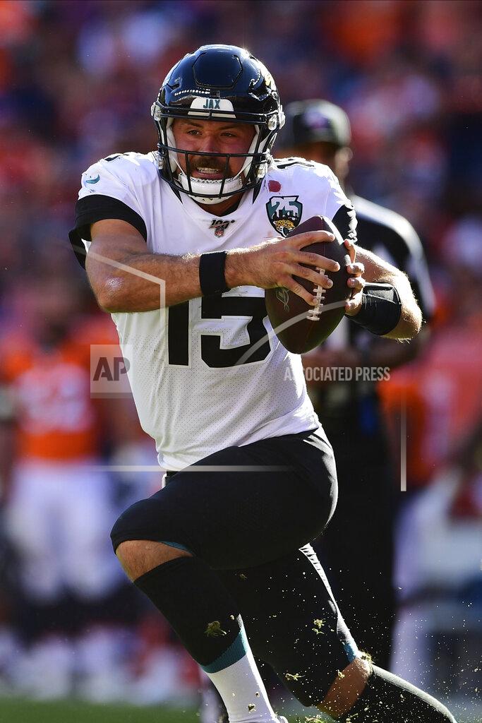Jacksonville Jaguars quarterback Gardner Minshew II (15) attempts to avoid a tackle during the second half in the NFL game against the Denver Broncos in Denver Sunday, Sept. 29, 2019.(Eric Bakke via AP)
