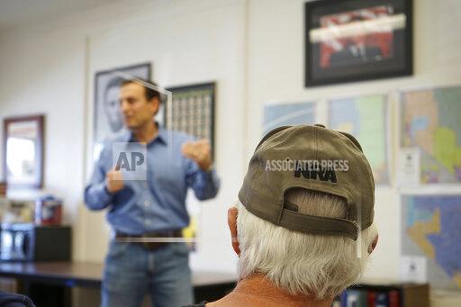In this Sunday, Oct. 10, 2021, photo Republicans listen as Senate candidate Adam Laxalt speaks at the Douglas County Republican Party Headquarters on the final day of his Senate campaign's statewide tour in Gardnerville, Nev. Republican Laxalt hopes to win the race for Nevada's U.S. Senate seat by drawing stark between his positions and the direction he says Democrats and their allies in Big Tech, Hollywood and the media are taking the country. (AP Photo/Sam Metz)