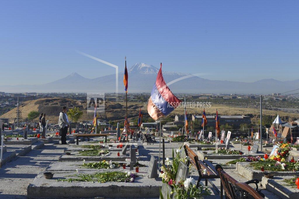Karo Sahakyan Relatives visit a military cemetery with the graves of Armenian soldiers killed during the fighting over Nagorno-Karabakh in 2020, outside Yerevan, Armenia, Monday, Sept. 27, 2021. Azerbaijan and Armenia are marking the first anniversary of the start of their six-week war in which more than 6,600 people died and that ended with Azerbaijan regaining control of large swaths of territory. In Yerevan, the Armenian capital, thousands of people went to the Yerablur military cemetery to pay respects to soldiers buried there. (Karo Sahakyan/PAN Photo via AP)