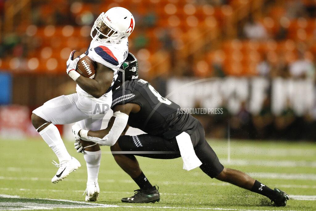 Marco Garcia Arizona running back J.J. Taylor (21) tries to get around Hawaii defensive back Eugene Ford (8) in the second half of an NCAA college football game, Saturday, Aug. 24, 2019, in Honolulu. (AP Photo/Marco Garcia)