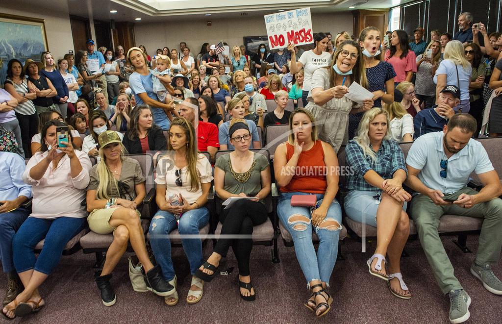 Rick Egan Angry residents react when the Utah County Commission meeting was adjourned before it even started, Wednesday, July 15, 2020, in Provo, Utah. The group protesting against face masks being required in schools removed the social distancing tape on the chairs and filled the Utah County Commission room to over flowing, prompting Commissioner Tanner Ainge to call for a vote to adjourn the meeting. (Rick Egan/The Salt Lake Tribune via AP)