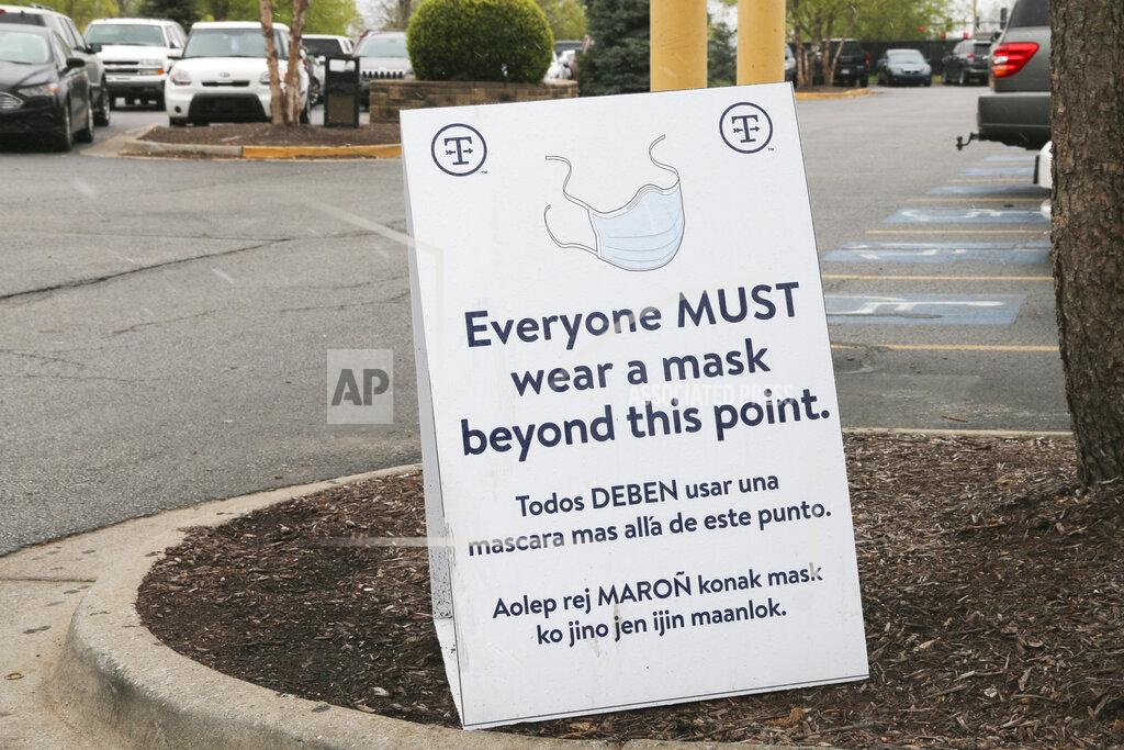 Abby Zimmardi In this image from the Howard Center for Investigative Journalism at the University of Maryland's Philip Merrill College of Journalism, outside of the Tyson Berry Street plant in Springdale, Arkansas, a sign in English, Spanish, and Marshallese stands reminding employees to wear a mask before entering the location, April 20, 2021. Tyson currently provides surgical-style face masks to its employees. (Abby Zimmardi/University of Arkansas via AP)