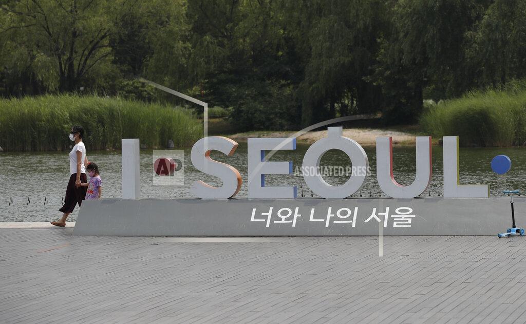 Visitors wearing face masks to prevent the spread of the new coronavirus walk at a park in Seoul, South Korea, Saturday, June 20, 2020. (AP Photo/Lee Jin-man)