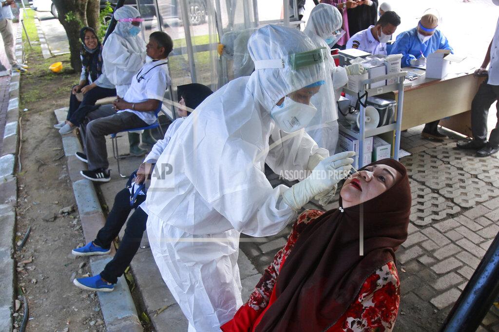 Binsar Bakkara A medical workers collect nasal swab samples from a woman to be tested for coronavirus during a COVID-19 screening at University of North Sumatra in Medan, Indonesia, Monday, June 21, 2021. Indonesia has reported more coronavirus cases than any other country in Southeast Asia. (AP Photo/Binsar Bakkara)