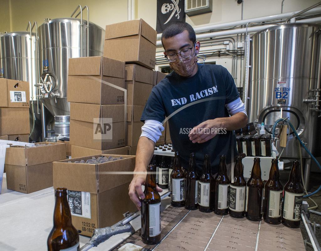 Rick Egan Jordan Vigil loads bottles in the brewery at Epic Brewing Co. in Salt Lake City, Thursday, Oct. 29, 2020. (Rick Egan/The Salt Lake Tribune via AP)