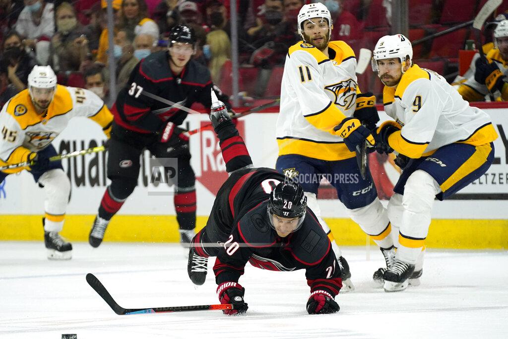 Gerry Broome Carolina Hurricanes right wing Sebastian Aho (20) is tripped while skating near Nashville Predators left wing Filip Forsberg (9) and center Luke Kunin (11) during the second period in Game 5 of an NHL hockey Stanley Cup first-round playoff series in Raleigh, N.C., Tuesday, May 25, 2021. (AP Photo/Gerry Broome)