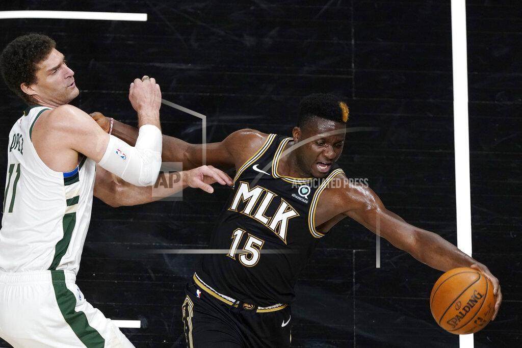 John Bazemore Atlanta Hawks center Clint Capela (15) reaches for the ball next to Milwaukee Bucks center Brook Lopez (11) during the second half of an NBA basketball game Thursday, April 15, 2021, in Atlanta. (AP Photo/John Bazemore)