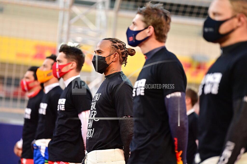 Andrej Isakovic Mercedes driver Lewis Hamilton of Britain, center, and other drives attend at the starting grid prior to the start of the Bahrain Formula One Grand Prix at the Bahrain International Circuit in Sakhir, Bahrain, Sunday, March 28, 2021. (Andrej Isakovic, Pool via AP)