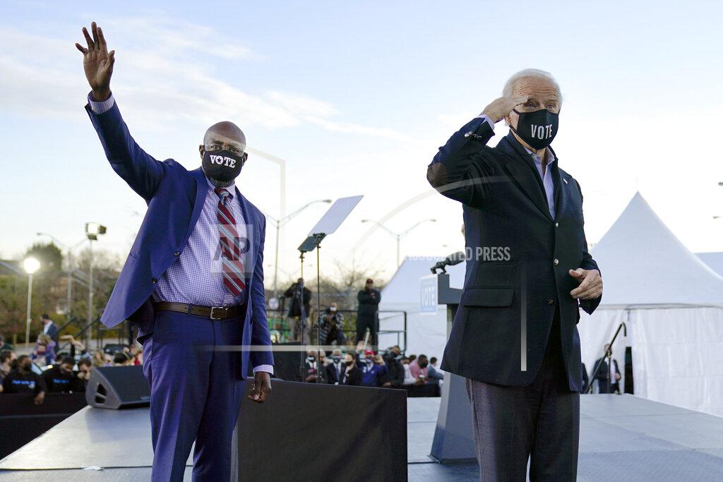 Carolyn Kaster FILE - In this Monday, Jan. 4, 2021 file photo, President-elect Joe Biden, right, campaigns for Senate candidates Raphael Warnock, left, and Jon Ossoff, not pictured, in Atlanta. Sen.-elect Warnock shares more than a party with Biden: Both Democrats made faith a central part of their political identity on the campaign trail — and their victories are emboldening religious liberals. (AP Photo/Carolyn Kaster)