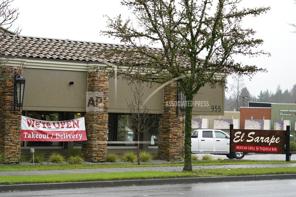 Ted S. Warren A sign at the El Sarape restaurant advertises takeout and delivery, Tuesday, Jan. 5, 2021, in Olympia, Wash. Indoor dining is currently prohibited in the state, and Washington Gov. Jay Inslee was scheduled to give an update on ongoing state efforts to slow the spread of COVID-19 at a news conference Tuesday afternoon. (AP Photo/Ted S. Warren)