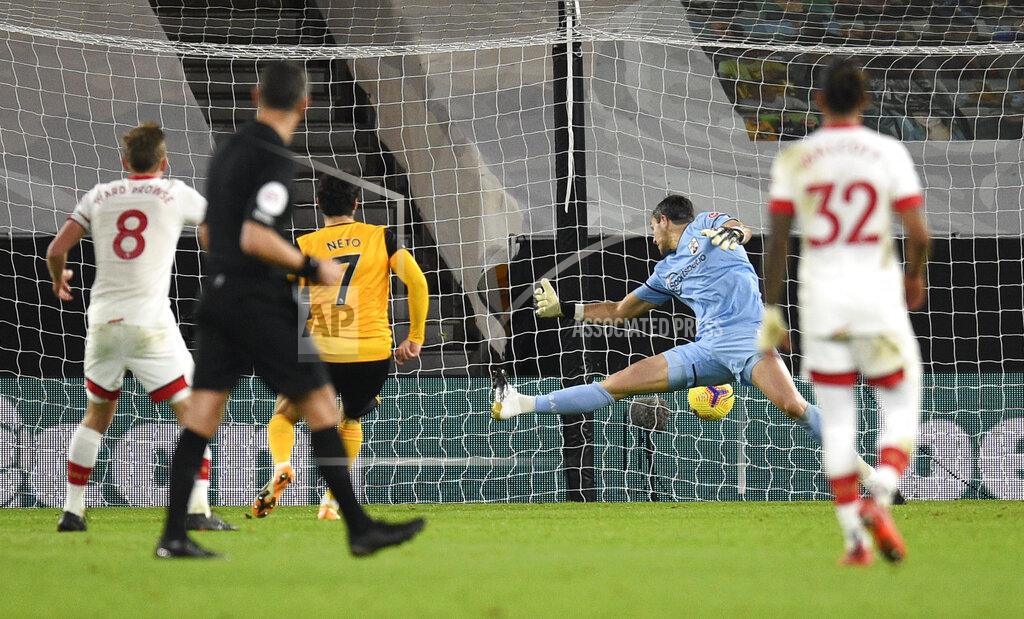 Oli Scarff Wolverhampton Wanderers' Pedro Neto, centre, kicks the ball past Southampton's goalkeeper Alex McCarthy to score his team's first goal during the English Premier League soccer match between Wolverhampton Wanderers and Southampton at Molineux Stadium in Wolverhampton, England, Monday, Nov. 23, 2020. (Oli Scarff, Pool via AP)