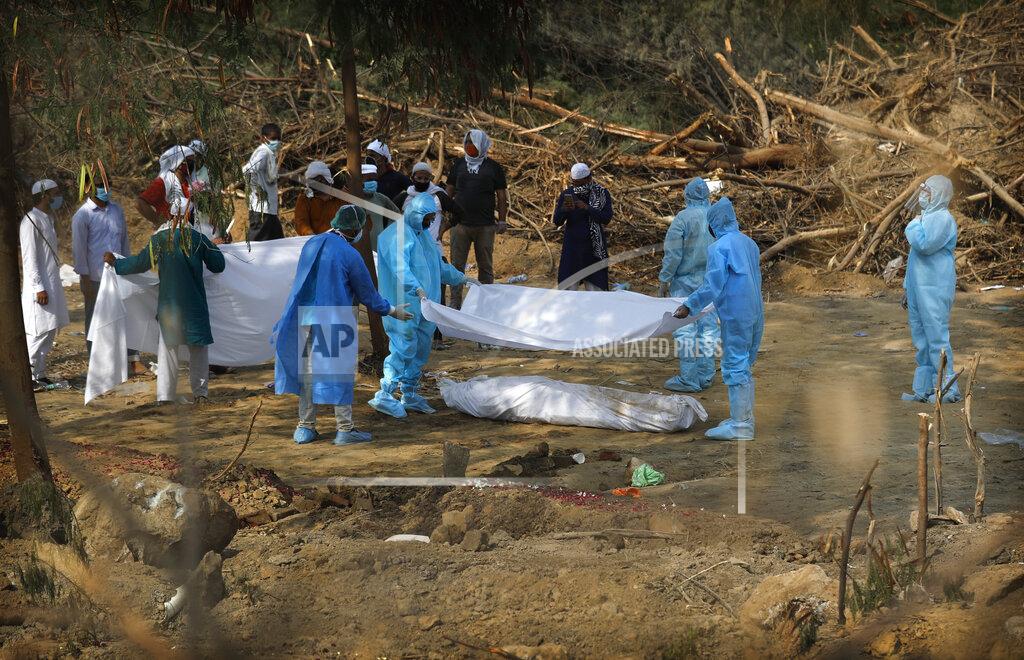 In this Wednesday, June 10, 2020 photo, people bury their relative who died of COVID 19 at a cemetery in New Delhi, India. Two and a half months of nationwide lockdown kept numbers of infections relatively low in India. But with restrictions easing in recent weeks, cases have shot up, raising questions about whether authorities have done enough to avert catastrophe. Half of Delhi’s 8,200 hospital beds dedicated to COVID-19 patients are already full and officials are projecting more than half a million cases in the city alone by July 31. (AP Photo/Manish Swarup)