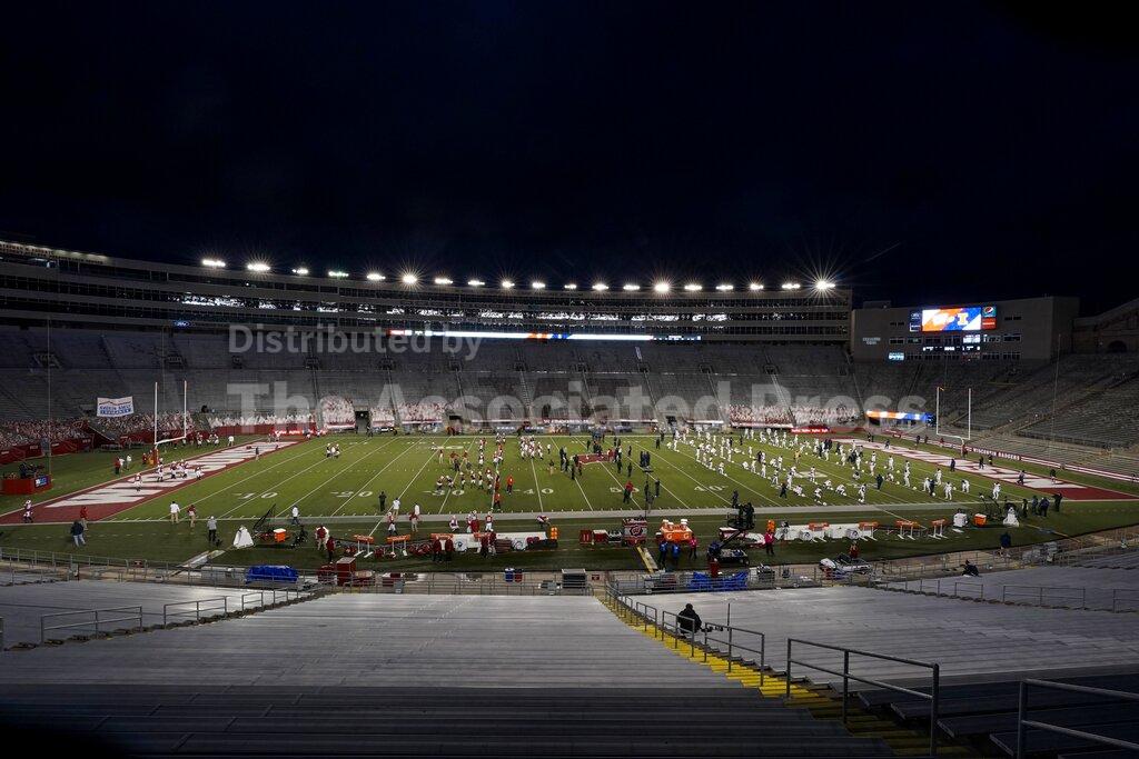 The seats at Camp Randall Stadium are empty as players warm up before an NCAA college football game between Wisconsin and Illinois Friday, Oct. 23, 2020, in Madison, Wis. (AP Photo/Morry Gash)