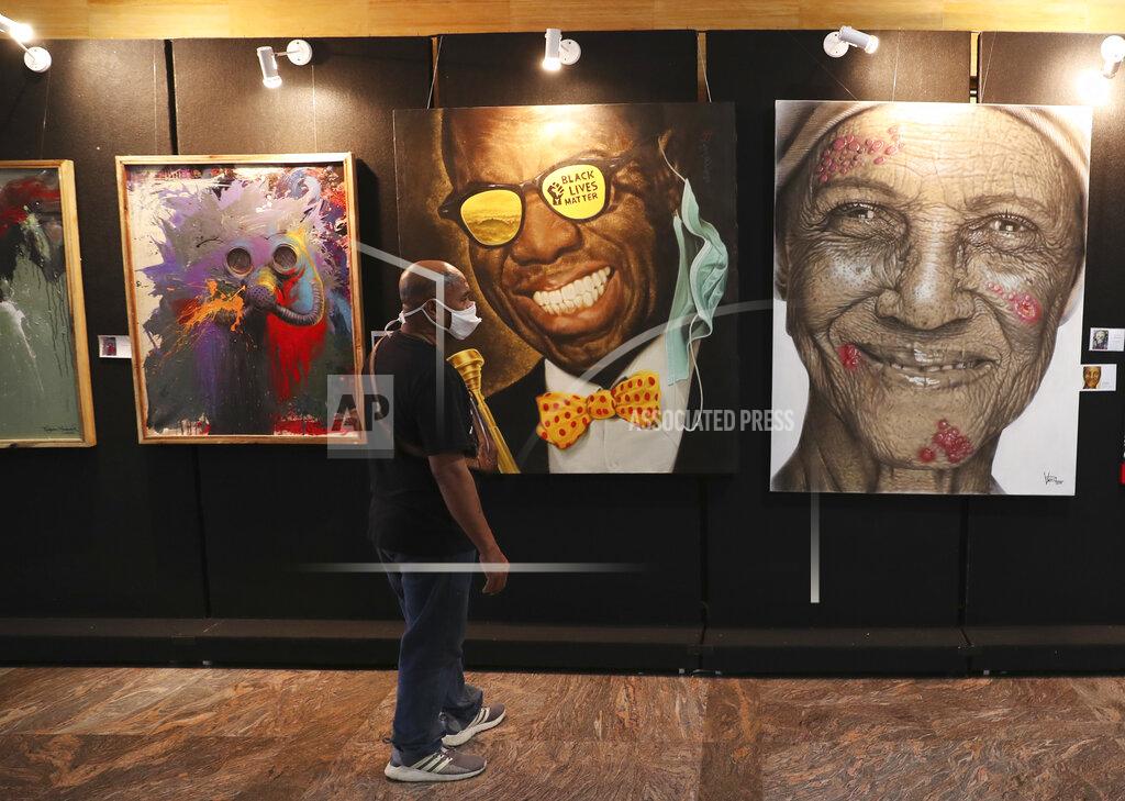 Achmad Ibrahim A man wears a face mask to help curb the spread of the coronavirus visits an art exhibition from Indonesian artists response to the pandemic in Jakarta, Indonesia, Thursday, Oct. 15, 2020. (AP Photo/Achmad Ibrahim)