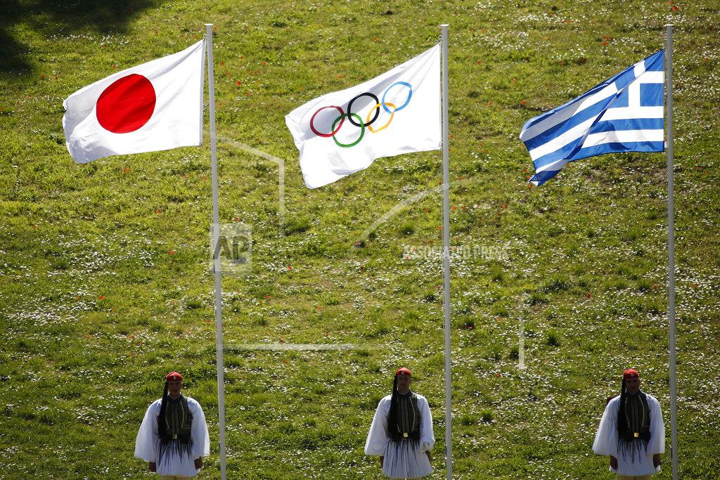 Yorgos Karahalis FILE - In this Thursday, March 12, 2020, file photo, Greek Evzones guards stand next to Japan, Olympic and Greece flags, from left, during the flame lighting ceremony at the closed Ancient Olympia site, birthplace of the ancient Olympics in southern Greece. U.S. President Donald Trump's suggestion to postpone the Tokyo Olympics for a year because of the spreading virus was immediately shot down by Japan's Olympic Minister Seiko Hashimoto. (AP Photo/Yorgos Karahalis, File)