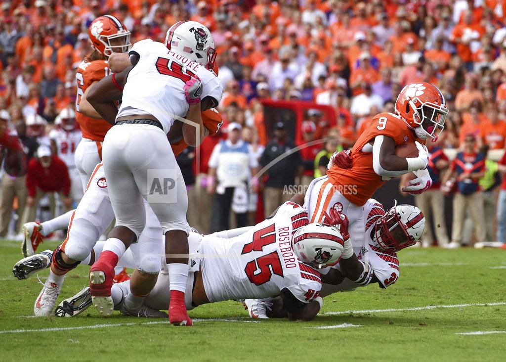 Richard Shiro Clemson's Travis Etienne (9) rushes while defended by North Carolina State's Darian Roseboro (45) and James Smith-Williams during the first half of an NCAA college football game Saturday, Oct. 20, 2018, in Clemson, S.C. (AP Photo/Richard Shiro)