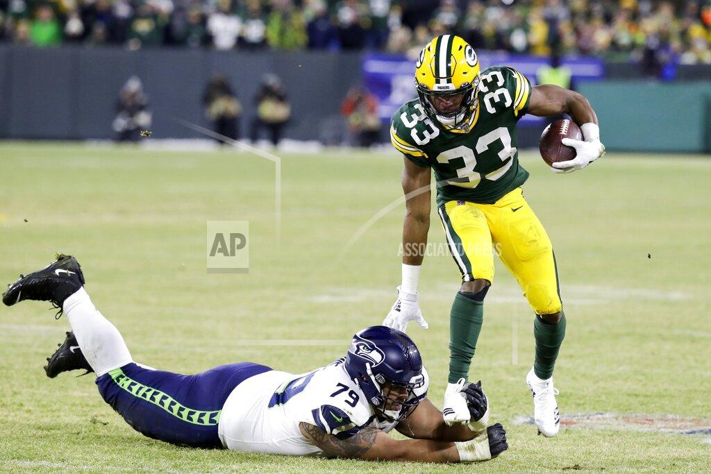 Darron Cummings Green Bay Packers' Aaron Jones runs past Seattle Seahawks' Bryan Mone during the first half of an NFL divisional playoff football game Sunday, Jan. 12, 2020, in Green Bay, Wis. (AP Photo/Darron Cummings)