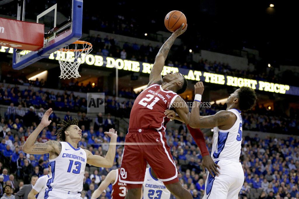 Nati Harnik Oklahoma's Kristian Doolittle (21) grabs a rebound between Creighton's Christian Bishop (13) and Ty-Shon Alexander (5) during the first half of an NCAA college basketball game in Omaha, Neb., Tuesday, Dec. 17, 2019. (AP Photo/Nati Harnik)