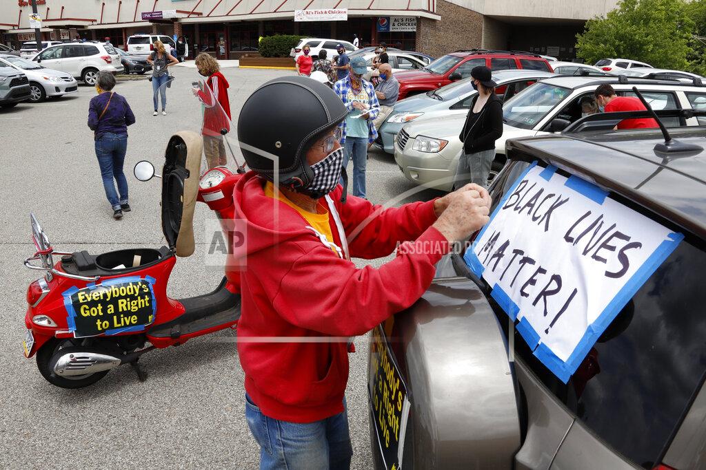 Gene J. Puskar FILE - In this June 14, 2020, file photo, Mel Packer of Pittsburgh tapes a sign on a vehicle in the parking lot of a Shop & Save in downtown Pittsburgh in preparation for the Pennsylvania Poor People's Campaign: National Call for Moral Revival. A national coalition of labor unions, along with racial and social justice organizations, will stage a mass walkout from work July 20, as part of an ongoing reckoning on systemic racism and police brutality in the U.S. (AP Photo/Gene J. Puskar, File)