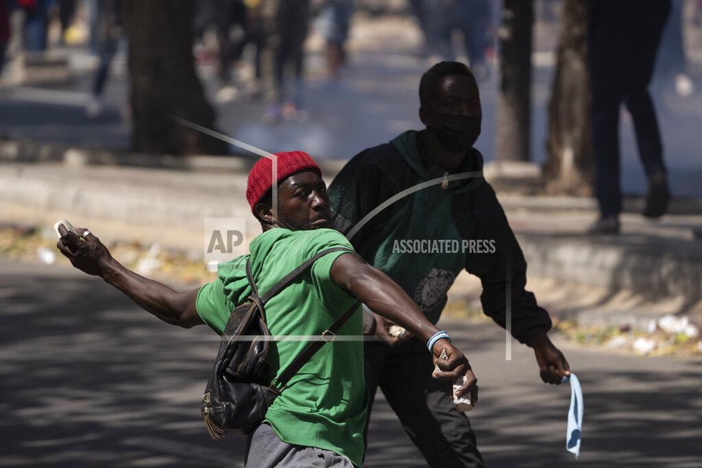 Leo Correa A demonstrators throws rocks at riot policemen during protests against the arrest of opposition leader and former presidential candidate Ousmane Sonko, Senegal, Monday, March 8, 2021. Senegalese authorities have freed opposition leader Ousmane Sonko while he awaits trial on charges of rape and making death threats. The case already has sparked deadly protests threatening to erode Senegal's reputation as one of West Africa’s most stable democracies. That's because Sonko's supporters are accusing President Macky Sall of pursuing the criminal charges to derail the opposition figure's prospects in the upcoming 2024 election. (AP Photo/Leo Correa)