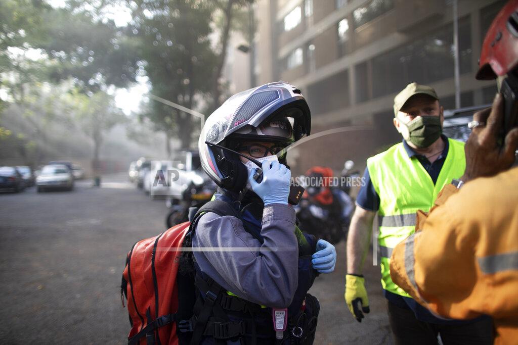 Ariana Cubillos Angels of the Road volunteer paramedic Zully Rodiz speaks on the radio as she arrives to a car fire at a parking lot in Caracas, Venezuela, Monday, Feb. 8, 2021. The volunteers keep a constant ear on walkie-talkie radio traffic and scan online chats dedicated to emergency services. (AP Photo/Ariana Cubillos)