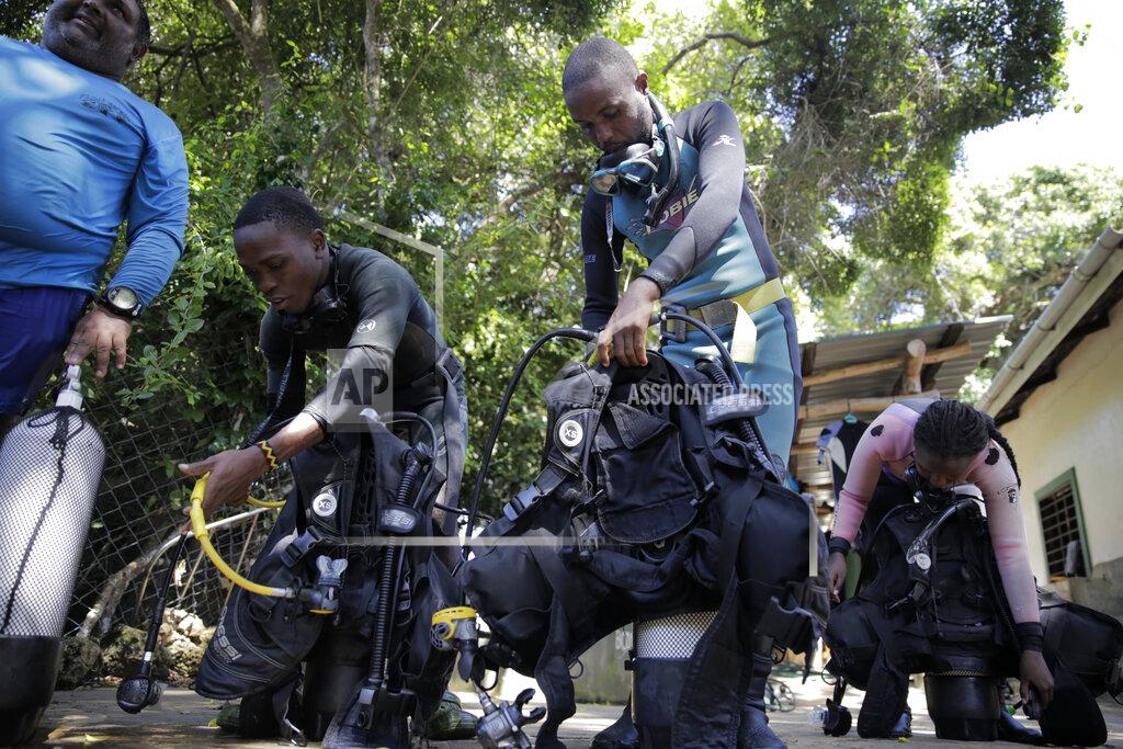 Brian Inganga Coral reef restoration rangers prepare to go dive and put artificial reef structures in the Indian Ocean in Shimoni, Kenya on Monday, June 13, 2022. The marine area off the coast of Kenya at Wasini Island, jointly managed by a foundation and the island's community, has been planting over 8,000 corals a year since 2010 and placed about 800 artificial reef structures in the channel in a bid to restore Wasini's coral gardens. (AP Photo/Brian Inganga)