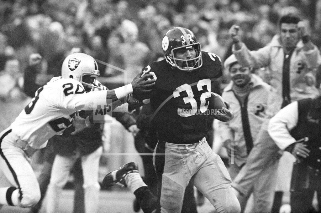 Harry Cabluck FILE - In this Dec. 23, 1972, file photo, Pittsburgh Steelers' Franco Harris (32) eludes a tackle by Oakland Raiders' Jimmy Warren as he runs 42-yards for a touchdown after catching a deflected pass during an AFC Divisional NFL football playoff game in Pittsburgh. Harris' scoop of a deflected pass and subsequent run for the winning touchdown, forever known as the "Immaculate Reception." (AP Photo/Harry Cabluck, File)