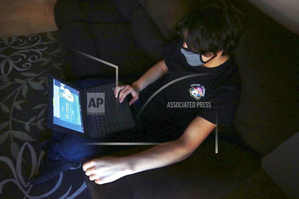 Cedar Attanasio Javin Lujan Lopez, 17, a senior at at Pojoaque High School logs into a remote learning site on his laptop, at his home in Espanola, N.M., Feb. 22, 2021. Javin isn’t sure what will happen after graduation. He's considering a welding certificate program at the local community college. He applied to universities in New Mexico and Colorado but feels like the pandemic year didn’t allow him to put his best foot forward. (AP Photo/Cedar Attanasio)