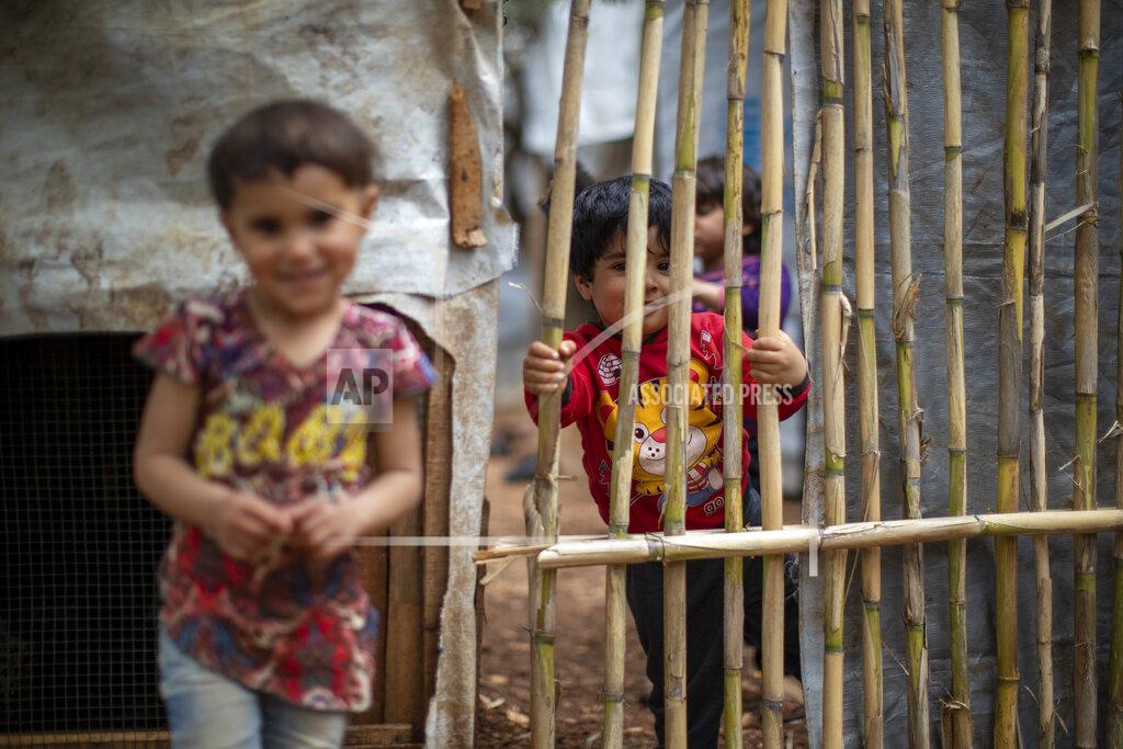Hassan Ammar Syrian refugee children pose for a photograph at an informal refugee camp, in the town of Rihaniyye in the northern city of Tripoli, Lebanon, Thursday, April 8, 2021. For many Syrian refugee families in Lebanon, Ramadan comes as a hard life of displacement has gotten even harder after a pandemic year that deepened economic woes in their host country. (AP Photo/Hassan Ammar)