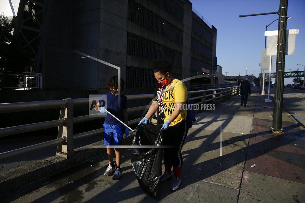 Brynn Anderson Derico Crump, 9, left, and Dayshell Crump, 30, clean the streets of downtown Atlanta in the aftermath of a demonstration against police violence on Saturday, May 30, 2020, in Atlanta. (AP Photo/Brynn Anderson)