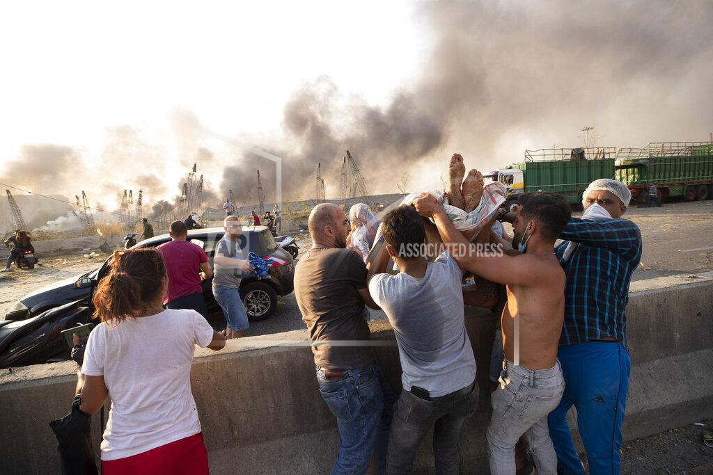 Hassan Ammar People evacuate wounded after of a massive explosion in Beirut, Lebanon, Tuesday, Aug. 4, 2020. Massive explosions rocked downtown Beirut on Tuesday, flattening much of the port, damaging buildings and blowing out windows and doors as a giant mushroom cloud rose above the capital. Witnesses saw many people injured by flying glass and debris. (AP Photo/Hassan Ammar)